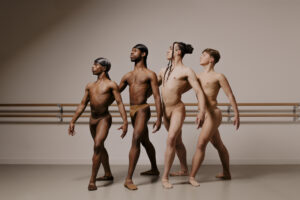 picture shows four adult male dancers posing in a line, left to right from darkest skin tone to lightest.